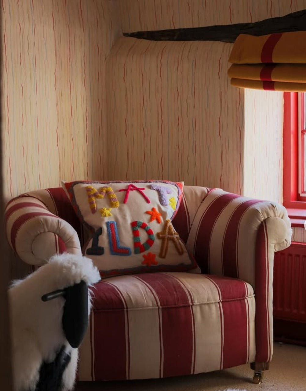 Customised Hand Made Punch Cushion by Big Little Store Africa sitting on a Striped Armchair